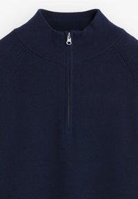 Navyblauwe half-zip pullover van ribstof. Beschikt over een hoge kraag en een zilveren ritssluiting met versterkte accenten op de schouders.