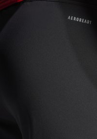 Zwarte aansluitende sportshorts van gladde, rekbare stof. Voorzien van het witte "AEROREADY" logo aan de achterkant.