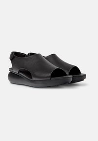 Sandali neri open-toe realizzati in pelle texturizzata, con suola in gomma spessa e fianchi ritagliati per ventilazione e stile.
