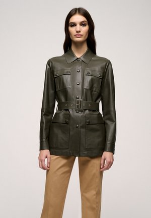 Veste en cuir vert foncé avec deux poches poitrine, une taille ceinturée et un col. Dotée de fermetures à boutons et d'une texture lisse.