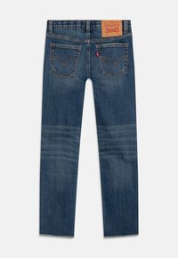 Jeans de mezclilla azul oscuro con un diseño de pierna recta, que cuentan con bolsillos traseros con costuras curvas y una etiqueta de cuero en la cinturilla.