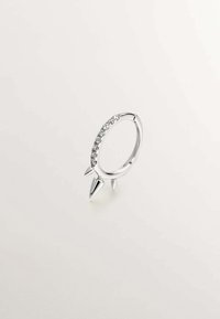 Anillo de aro de plata con una fila de piedras transparentes y tres acentos puntiagudos. Acabado suave con una superficie pulida y reflectante.