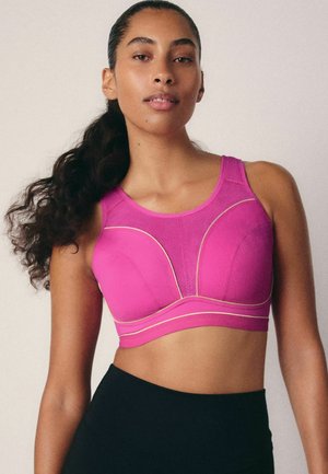 Roze sportbeha met gestructureerde naden en gouden accenten. Heeft een ronde halslijn en brede banden, gemaakt van een rekbare stof.