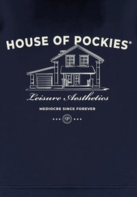 Sudadera azul marina con texto blanco y un gráfico de una casa. El texto incluye "HOUSE OF POCKIES", "Leisure Aesthetics" y "MEDIOCRE SINCE FOREVER."