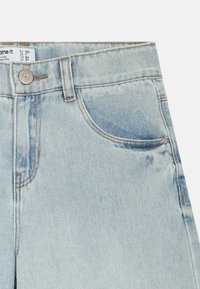 Hele sinised teksapüksid pleekinud viimistlusega, esitasku, metallist nööpidega ja kontrastse õmblusega.