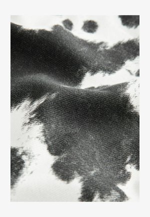 Black and white fabric with a loose weave, featuring abstract ink-like patterns and a textured surface that creates depth and variation.