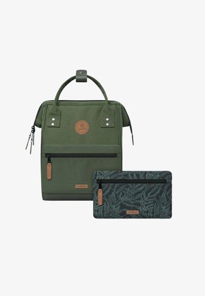 Green canvas backpack with top handle, front zipper pocket, and leather accents. Includes a smaller pouch with a leafy pattern.