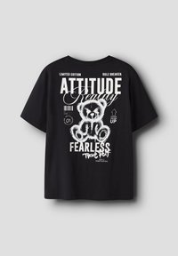 Μαύρο κοντομάνικο μπλουζάκι με άσπφο γραφικό ενός αρκουδάκι και κείμενο που περιλαμβάνει τις λέξεις "Στάση", "Ατρόμητος" και "Αληθινό Εγώ".