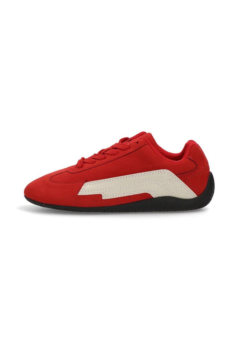 Zapatilla de ante roja con detalles en cuero blanco, perfil bajo, suela de goma negra y diseño de cordones. Presenta un acabado texturizado en la parte superior.