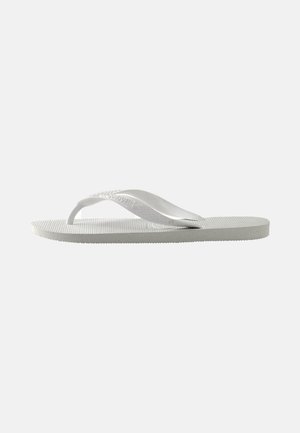 Chinelo branco com uma sola texturizada e duas tiras finas. As tiras são lisas com uma marcação subtil. Sem padrões ou acentos adicionais.