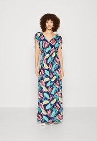 Abito lungo con sfondo blu navy e motivi di foglie colorate in rosa, giallo e verde. Scollo a V e maniche corte con lacci sulle spalle.