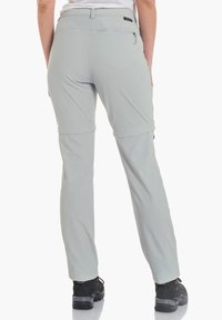 Pantalones exteriores de color gris claro, que absorben la humedad, con puños ajustables. Cuentan con un bolsillo trasero con cremallera y costuras reforzadas.