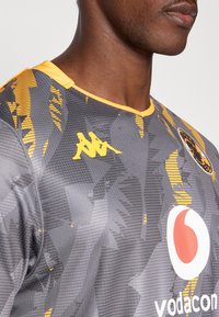 Szürke mez sárga részletekkel, texturált mintával. Kappa logó sárgában, Vodafone márkajelzés fehérrel és piros körrel, a gallér sárga színű.