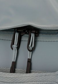 Sacca azzurro chiaro con zip, caratterizzata da un'esterno liscio, zip grigia e hardware nero con cordini testurizzati.