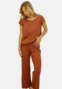 Ensemble de vêtements d'intérieur marron côtelé comprenant un haut à manches courtes avec un col rond et un pantalon ample assorti à taille élastique.