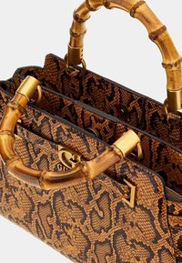 Håndtaske med bambushåndtag, der har et tekstureret mønster i brunt og sort leopard, med guldfarvede beslag og et struktureret design.
