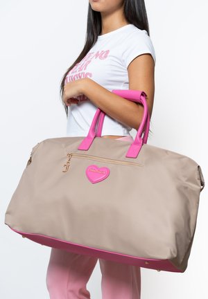 Große beige Nylon-Tasche mit pinken Akzenten, einschließlich der Griffe und einem Herzdetail. Verfügt über einen Reißverschluss und goldene Beschläge.
