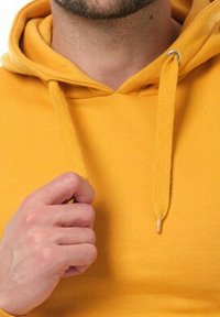 Haut à capuche jaune avec une poche avant, des cordons de serrage et un col rond. Le matériau semble doux et texturé. Les extrémités des cordons de serrage sont en bois.