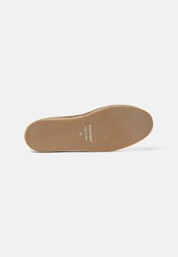 Suela de un zapato de goma marrón con detalles de yute trenzado alrededor del borde y la etiqueta "SCAROSSO MADE IN ITALY 42" visible en la parte inferior.