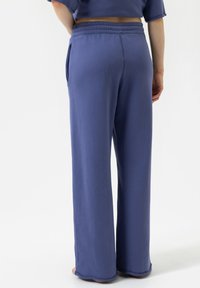 Lichte, relaxed-fit sweats in zachte, gestructureerde paarse stof. Voorzien van wijde pijpen, een elastische tailleband en zijzakken.