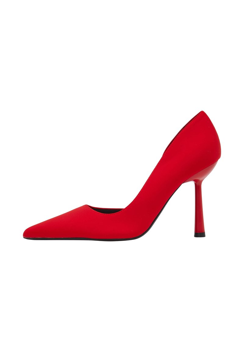 Scarpa con tacco alto a punta rossa, caratterizzata da una texture liscia e un tacco sottile. Presenta una suola nera e un design minimalista.