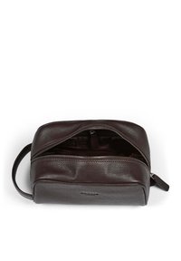 Brun läderväska med strukturerad yta, dragkedjestängning och ett handtag. Insidan har ett enfärgat foder och en liten ficka.