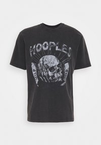 Černé bavlněné tričko s grafickým potiskem lebky a nápisem "KOOPLES" nad ní. Krátké rukávy a volný střih.