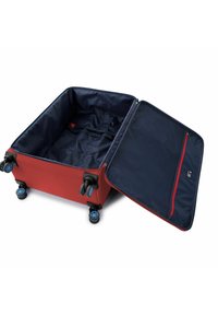 Red suitcase with a navy interior, four multi-directional wheels, and a zippered pocket. Open with adjustable straps for securing contents.