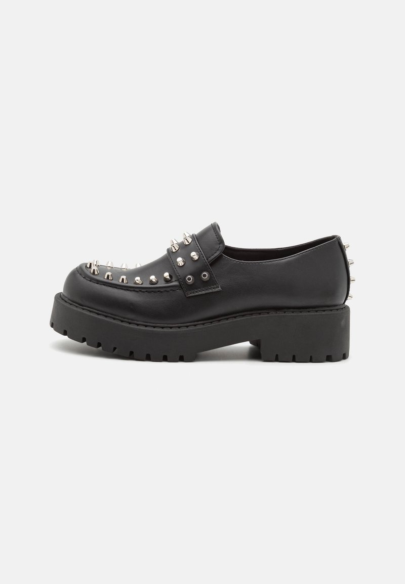 Mocassin chunky noir avec des pointes argentées le long du devant, de la bride et du talon, doté d'une semelle épaisse rainurée et d'une finition cuir lisse.