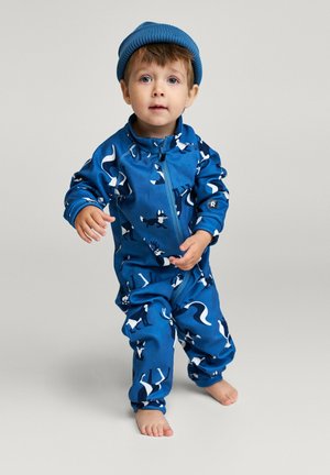 Blauer Reißverschluss-Overall mit Tiermustern, langen Ärmeln und passendem blauen Beanie. Der Stoff scheint weich mit einer glatten Textur zu sein.