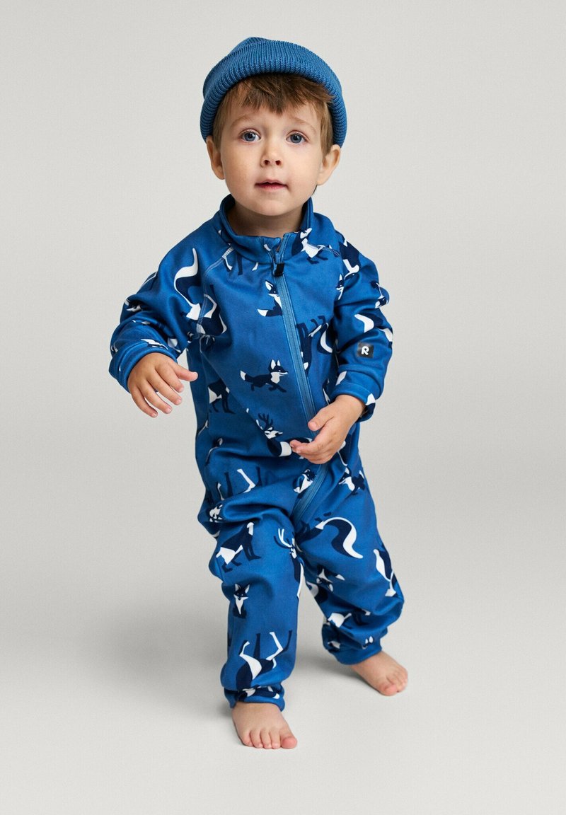 Blauer Reißverschluss-Overall mit Tiermustern, langen Ärmeln und passendem blauen Beanie. Der Stoff scheint weich mit einer glatten Textur zu sein.