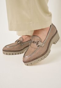 Bruine geweven loafers met een metallic accent, textuur oppervlak en dikke rubberen zool. De schoenen hebben een klassiek ontwerp met gedetailleerde stiksels.