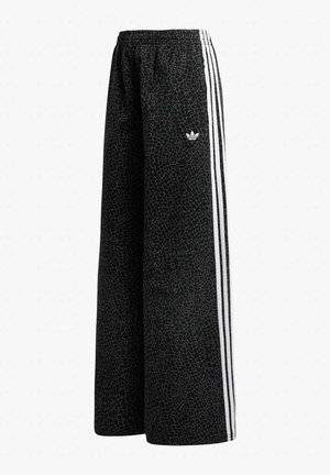 Pantaloni neri a gamba larga con motivo testurizzato sottile, vita elastica, tre strisce bianche lungo i lati e piccolo logo Adidas bianco sulla coscia sinistra.