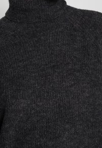 Dunkelgrauer gestrickter Rollkragenpullover mit einem strukturierten Wollmuster, von hinten und über die Schultern gezeigt.