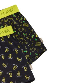 Bóxer de algodón negro con gráficos vibrantes de alienígenas y OVNIs en verde. Presenta una cinturilla de color verde neón etiquetada como "PLAYER". Varios patrones con temática espacial.