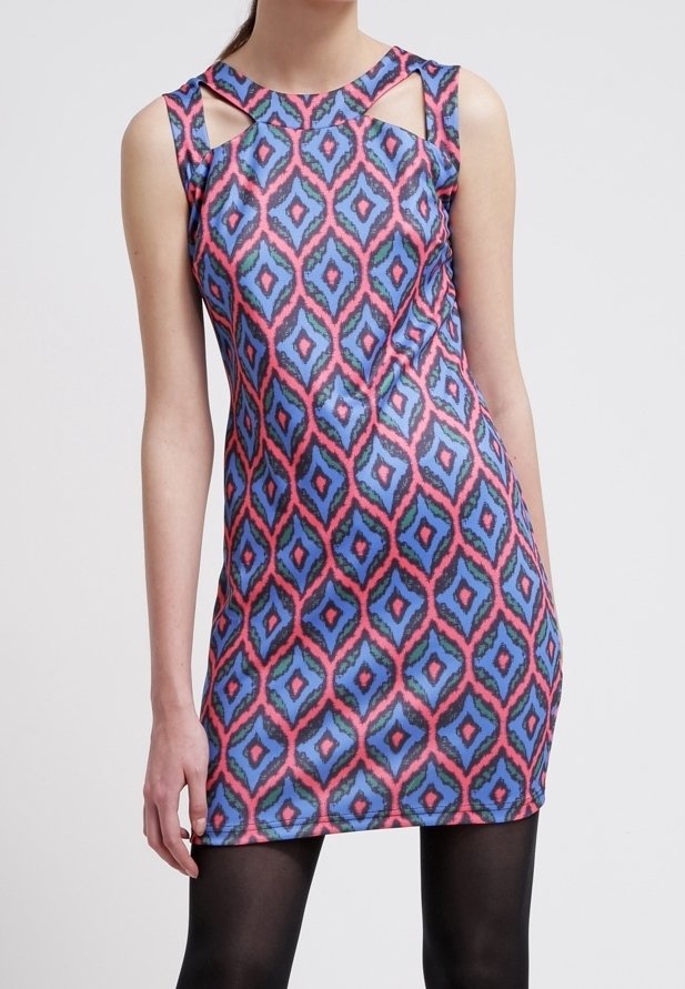 Robe sans manches et ajustée avec motif losanges bleu, rose et noir et détails découpés près des épaules, portée avec des collants noirs.