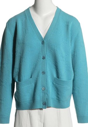 Cardigan en maille bleu clair avec col en V, cinq boutons à l’avant, deux poches devant et poignets et ourlet côtelés.