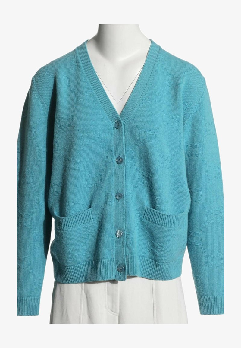 Cardigan en maille bleu clair avec col en V, cinq boutons à l’avant, deux poches devant et poignets et ourlet côtelés.