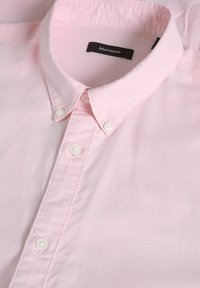 Camicia button-up rosa chiaro con colletto classico, bottoni bianchi e una texture di cotone liscia; l'etichetta del marchio riporta "Matinique".