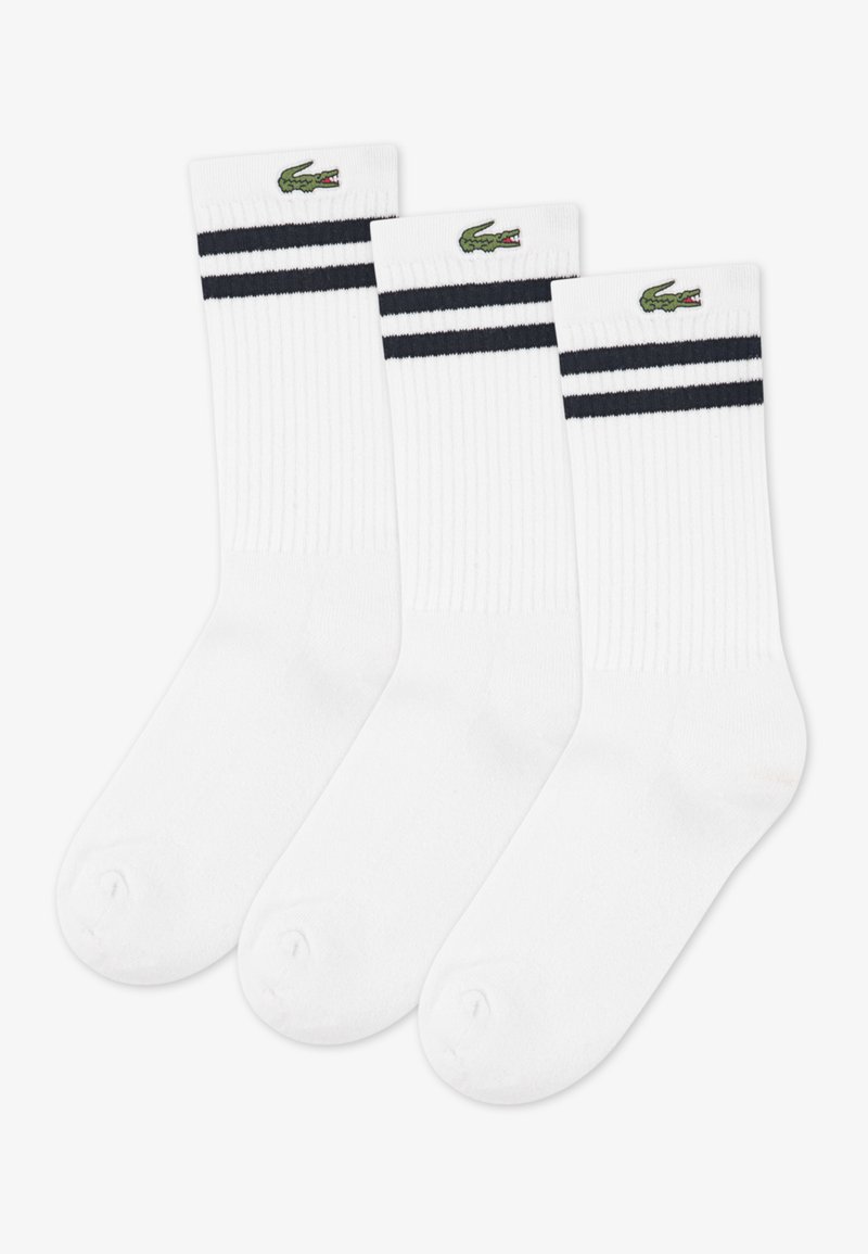 Chaussettes blanches côtelées pour la cheville avec deux rayures bleu marine en haut et un logo crocodile vert. Lot de trois paires.