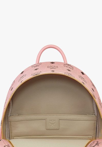 Zaino rosa realizzato in materiale testurizzato, con forma rotonda, cerniera dorata e scomparto interno con patch del logo.