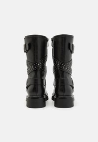 Black faux leather boots with a mid-calf design, featuring buckle accents and studded straps. Textured finish with a sturdy sole.