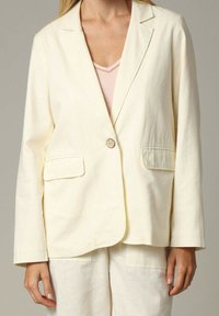 Linnen blazer in lichtgeel, voorzien van een enkele knoopsluiting, twee voorzakken en een ontspannen pasvorm met lange mouwen.