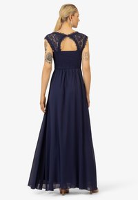 Navyblauwe maxi-jurk met kanten kapmouwen en een gerimpelde body. Vloeiende rok, keyhole rugdetail. Zacht, lichtgewicht materiaal.