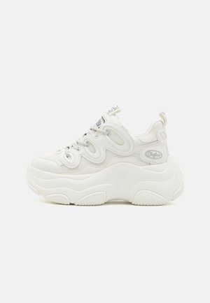 Valged killud sneakerid, millel on võrgust ja sünteetilisest materjalist pealispind, kõver kuju, tekstureeritud tallaosa ning silmatorkav paeltesüsteem logode detailidega.