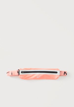 Cinturón de cintura Nike de color rosa coral con cremallera negra y correa ajustable con el logo de Nike en negro sobre fondo blanco.