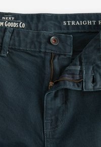 Donkerblauwe denim jeans met een rechte pasvorm. Voorzien van een metalen ritssluiting, knoopsluiting en een merkband. Gestructureerde stof met zichtbare stiksels.