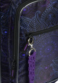 Borsa di stoffa nera con un intricato design a motivi viola e blu. Presenta una zip prominente e un accenno di portachiavi testurizzato viola.