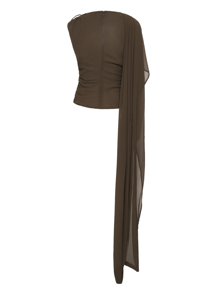 Haut asymétrique marron foncé sans bretelles avec un côté froncé et un long tissu fluide drapé sur une épaule.