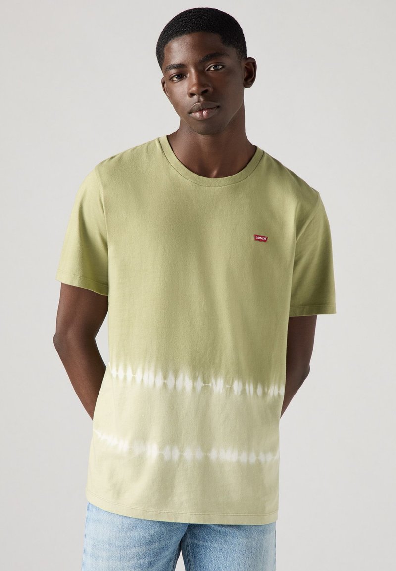 T-shirt em tie-dye verde-oliva com decote redondo e mangas curtas. Apresenta um pequeno logótipo vermelho da Levi's no lado superior esquerdo.